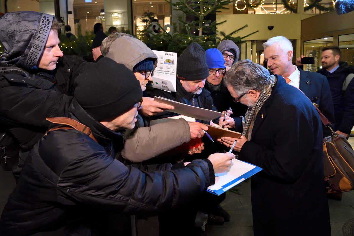 Semenza begins to sign autographs in notebooks and on photographs for the gathered crowd.